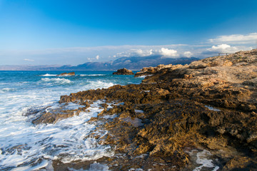 The rocks are in contact with the sea. Rocky beach, sharp rocks touching the sea,.