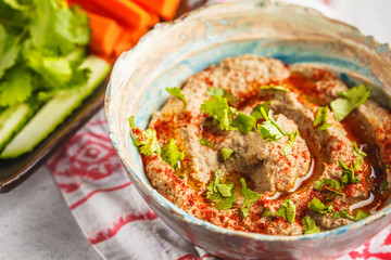 Middle Eastern cuisine: baba ganoush with vegetables in a plate on white background.