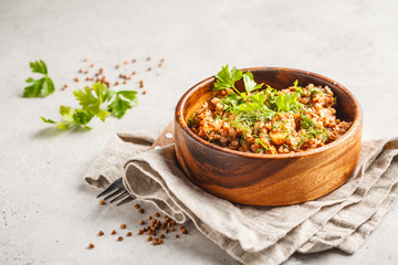 Buckwheat with meat in a wooden bowl on a white background, copy space.