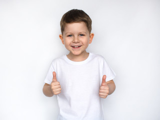 little cute  boy in a white t-shirt showing thumbs up,  ok sign