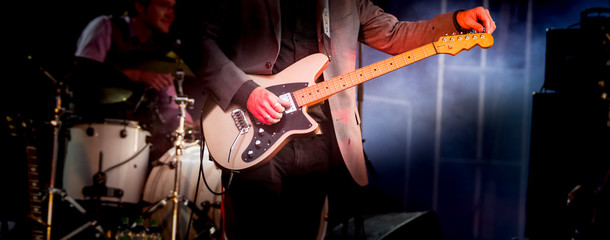 Man guitarist bass guitar instrument performing at stage rock music.