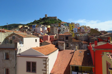 Colourful houses in the medieval town of Bosa with the castle of Serravalle towering over the red...