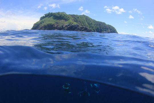 Scuba divers and island over under   