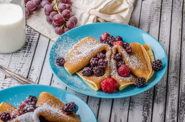 Homemade crepes with frozen berries, topped sugar