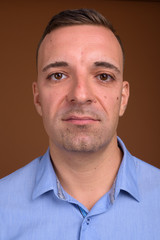 Businessman wearing blue shirt against brown background