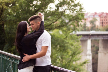 Young couple, a guy with a girl hugging in the park.