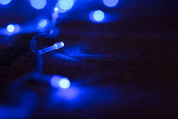 soft focus night winter holidays decoration with blue garland illumination sparkles and bokeh...