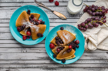Homemade crepes with frozen berries, topped sugar