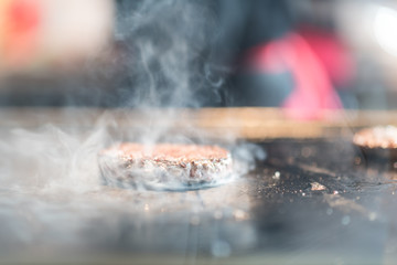 Fresh meat cutlets in a frying pan grill. A lot of steam or smoke