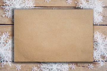 Wooden brown christmas background with snowflakes and old brown paper with space.