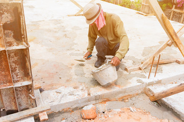 construction workers were plastering repair floor in workplace build a house. select focus bucket mortar with copy space add text