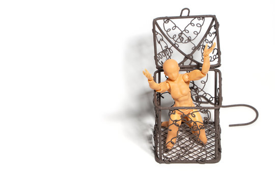 Action figure sitting and hold two hands above the head in open steel cage on isolate background, Concept of tolerance in comfort zone do not dare to change and Fear of change