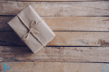 Above brown gift box on wooden table background with copy space.