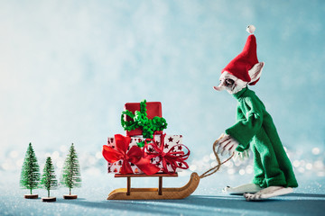 Cute Cheerful Santas Helper Elf Loading Christmas Gifts Onto Santas Sleigh. North Pole Christmas...