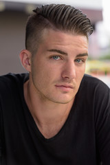 Obraz premium Face of young handsome man sitting outdoors