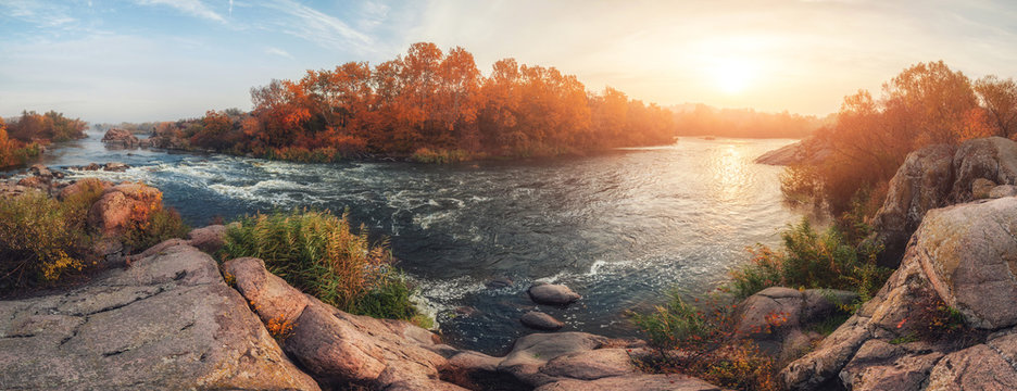 amazing panoramic  view of  blue foggy river and colorful forest on sunrise. autumn landscape