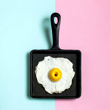 Cast-iron frying pan with fried eggs, ball of yarn instead of yolk