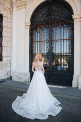 Beautiful blonde hair bride near the pacale. Women in an elegant white wedding dress