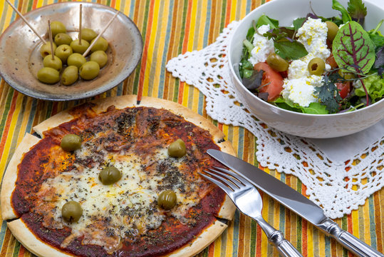pitted olives margarita pizza with olives and cottage cheese with olives and tomatoes fresh green salad close-up