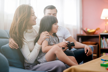 little girl and parent family playing video game at home