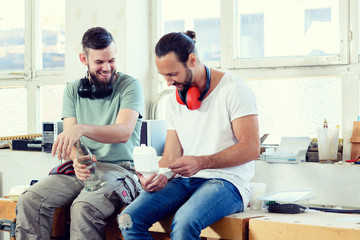 two worker in a carpenter's workshop taking a break