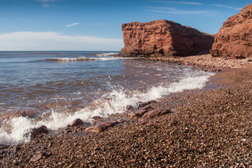 Small waves crashing alone north western shoreline of Prince Edward Island