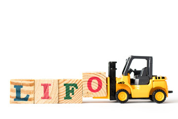 Toy forklift hold letter block o to complete word LIFO (Abbreviation of last in first out) on white background