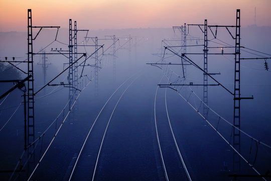 railways & electricity pylons at sunset, industrial landscape