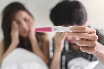 Unhappy couple young asian woman and man holding pregnancy test showing a negative result, Wellness and healthy concept, Infertility problem.