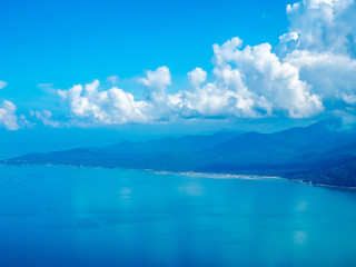Island and beach under cloudy blue sky