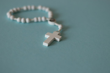 white rosary on blue background