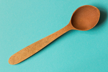 Old wooden spoon. Isolated on blue background