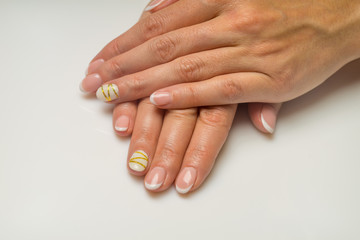 Naklejka premium French manicure and nail gel Polish. The decoration of the nail white and gold decor. Top view Close-up photography