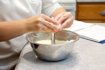 Obraz na płótnie Canvas Cracking egg into mixing bowl