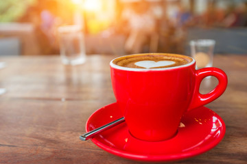 Heart latte art hot coffee on the wooden table with sunlight as love and happy valentine's day concept