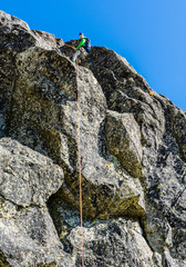 Satisfied mountain climber completes the climb. Rappeling.