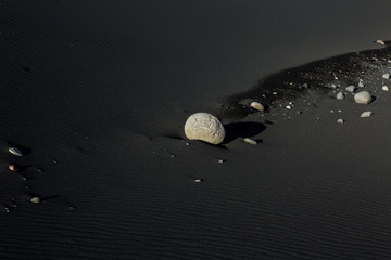 Grey lava stones in iceland. Vulcanic sand beach. Volcanic rock on black sand.