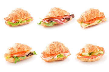 Assorted croissant sandwiches on a white surfase isolated.