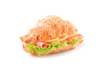 Croissant sandwich with smoked salmon, leaf lettuce and lemon on white surface isolated.