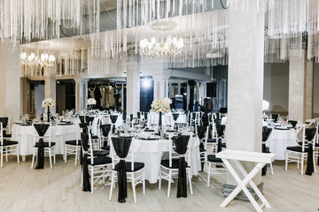 Beautifully decorated tables for guests. Wedding preparation catering service in black and white style