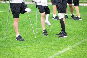 close-up of ampute soccer player and team friend