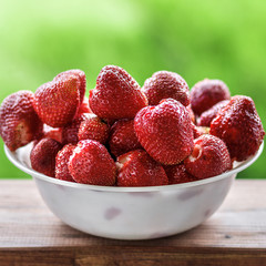 Fresh juicy large strawberry in a bowl close-up outdoors at the cottage