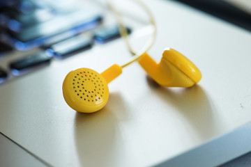 Yellow headphones connected to a silver desktop computer.