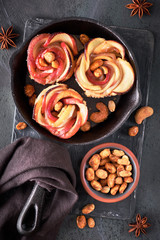 Three homemade puff pastries with rose shaped apple slices baked in cast iron skillet