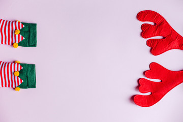 christmas background. minimalistic flat lay top view of reindeer antlers and elf socks. perfect for a festive merry xmas greeting card. enough room for copy space and text.