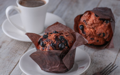 Mafins with chocolate and cherry jam. Listed on a light wooden board and white curry with coffee