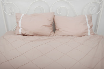 Bedclothes on the bed made with pillows.