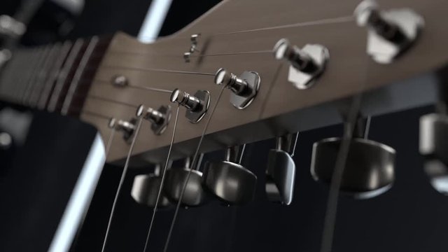 Close camera movement on electric guitar neck in dark room with spining tuning peg