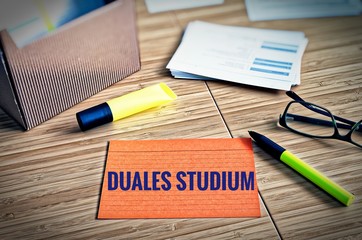 Index cards with legal issues with glasses, pen and bamboo with the german words Duales Studium in...