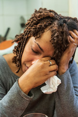 Sad, depressed afro american woman crying in the kitchen. Home violence concept.